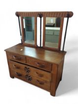 An Arts & Crafts oak dressing chest with pair of mirrors to the