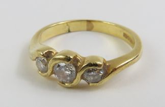 An 18ct gold diamond three stone ring, the three r