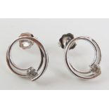 A pair of 9ct white gold stud earrings, the open c