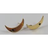 A pair of crescent moon shaped stud earrings, each