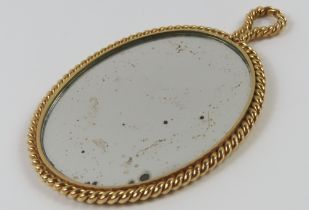An oval handbag mirror, with a plaited pattern to