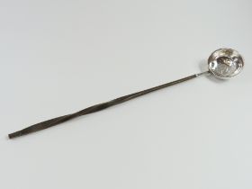 An angled ladle with silver bowl and connecting fe