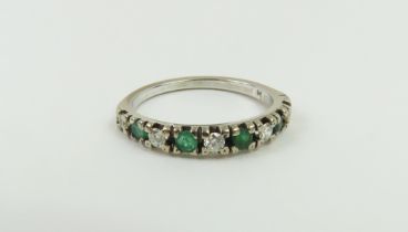 An 18ct white gold emerald and diamond half eterni