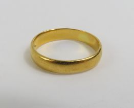 A 22ct gold wedding band, finger size L leading ed