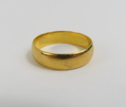 A wide 22ct gold wedding band, finger size R centr