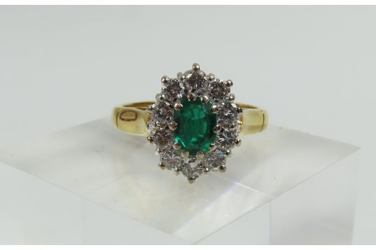 An 18ct gold emerald and diamond cluster ring, the - Image 1 of 5