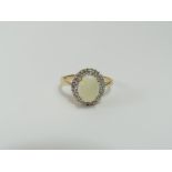 A 9ct gold white opal and diamond cluster ring, th