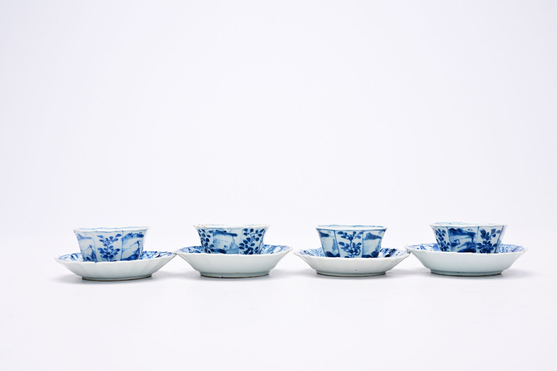 Four Chinese blue and white cups and saucers with floral design and landscapes, Kangxi