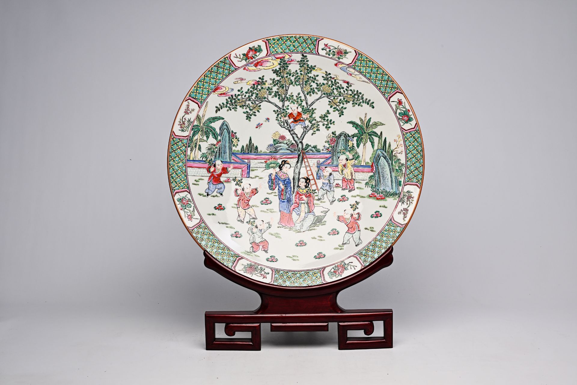 A large Chinese famille rose dish with ladies and children in a landscape, Qianlong mark, 20th C.