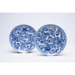 A pair of Chinese blue and white plates with floral design and animated landscapes, Kangxi