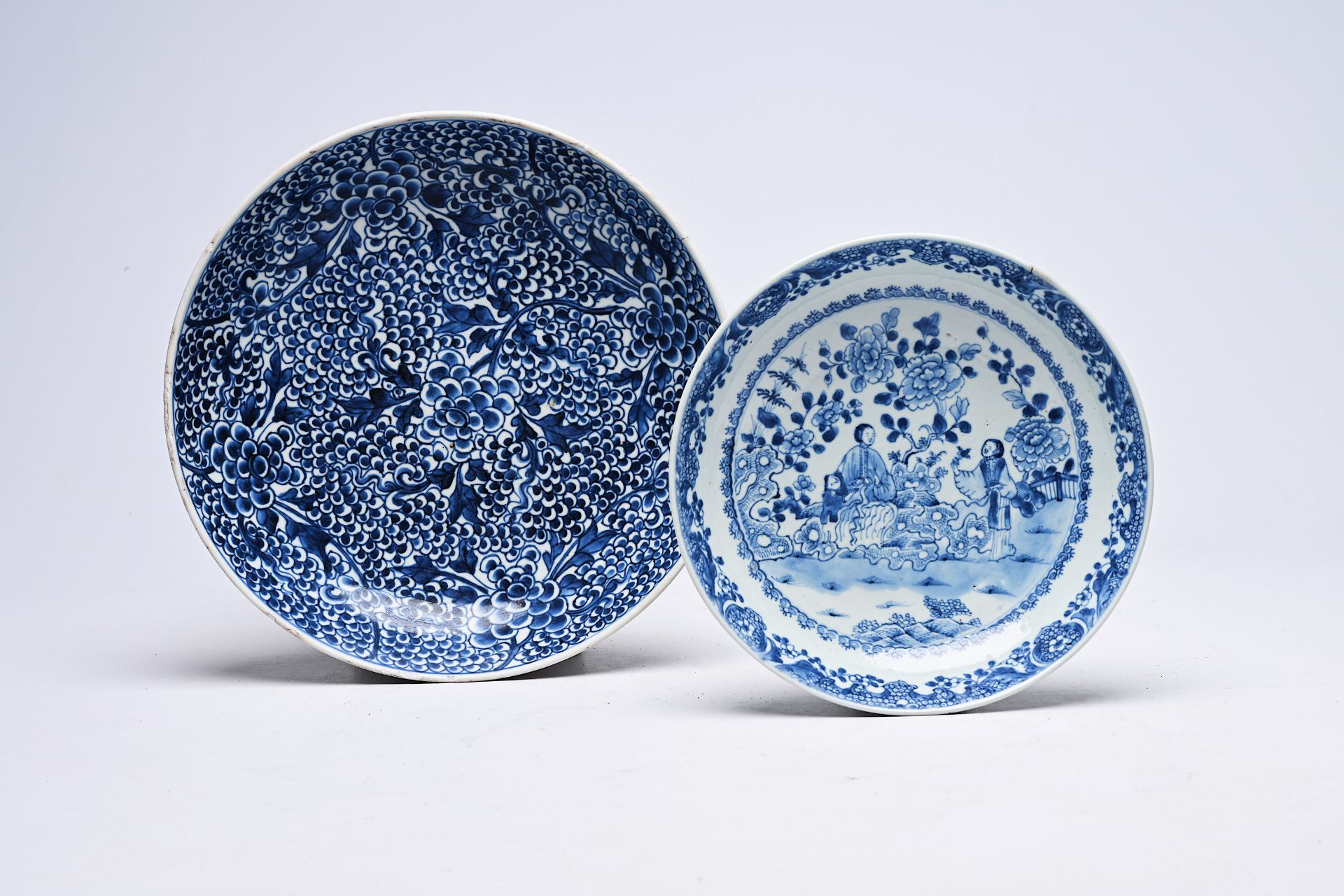 Two Chinese blue and white plates with floral design and figures in a landscape, Kangxi/Qianlong