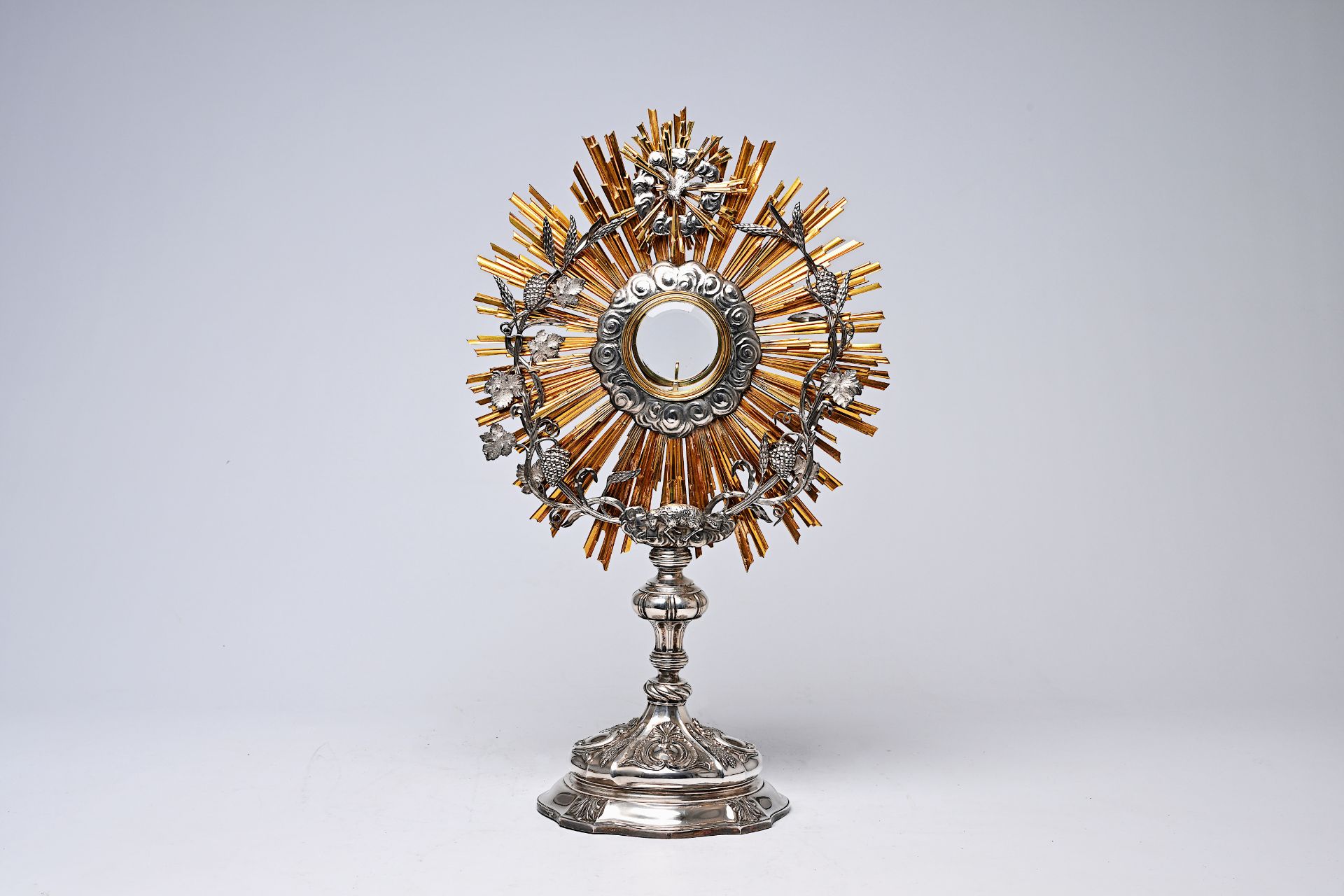 A Belgian partly gilt silver monstrance with grape vines, the Mystic Lamb and the Holy Spirit, dated