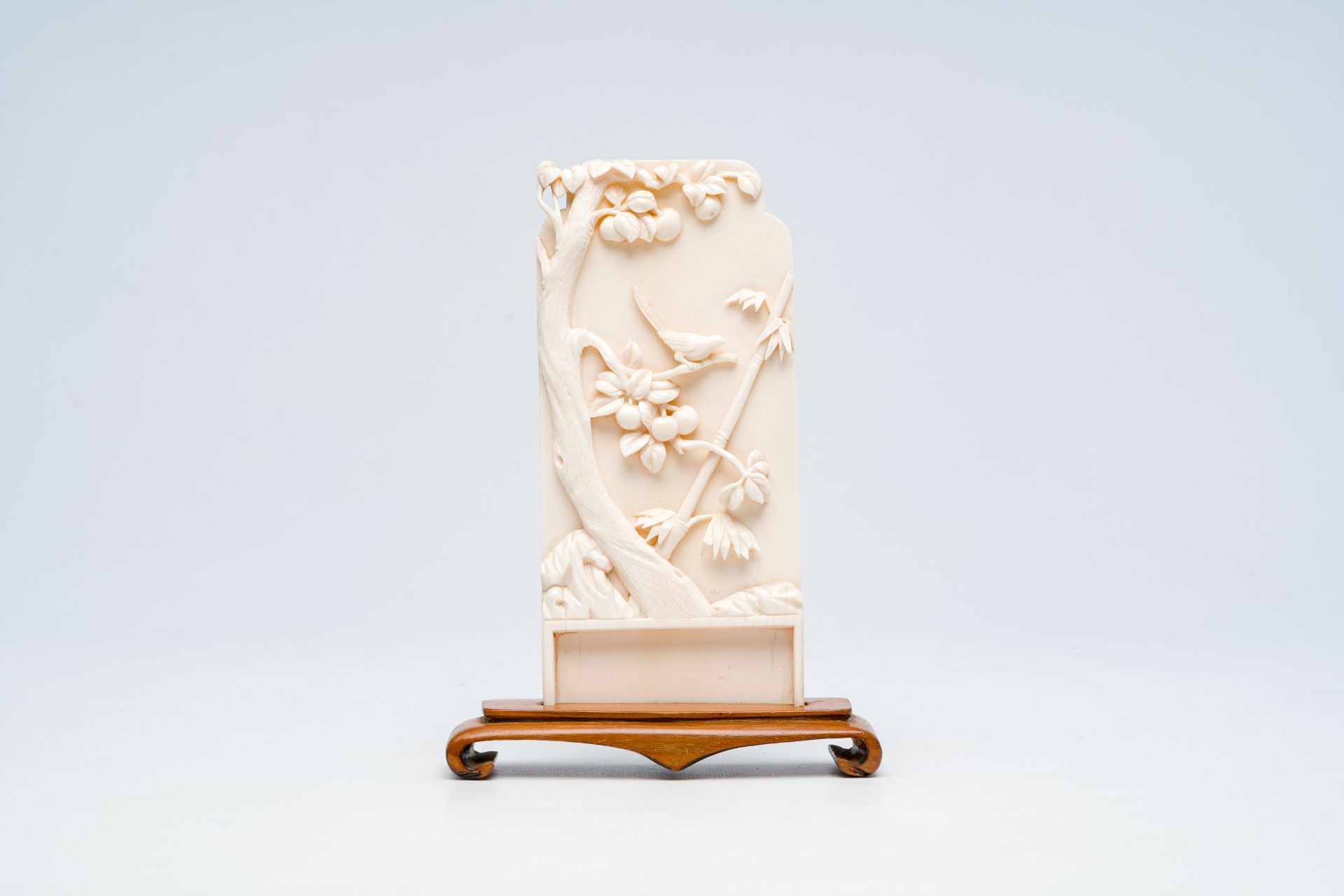A Chinese ivory plaque with a bird on a branch in relief, 19th/20th C.