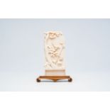 A Chinese ivory plaque with a bird on a branch in relief, 19th/20th C.