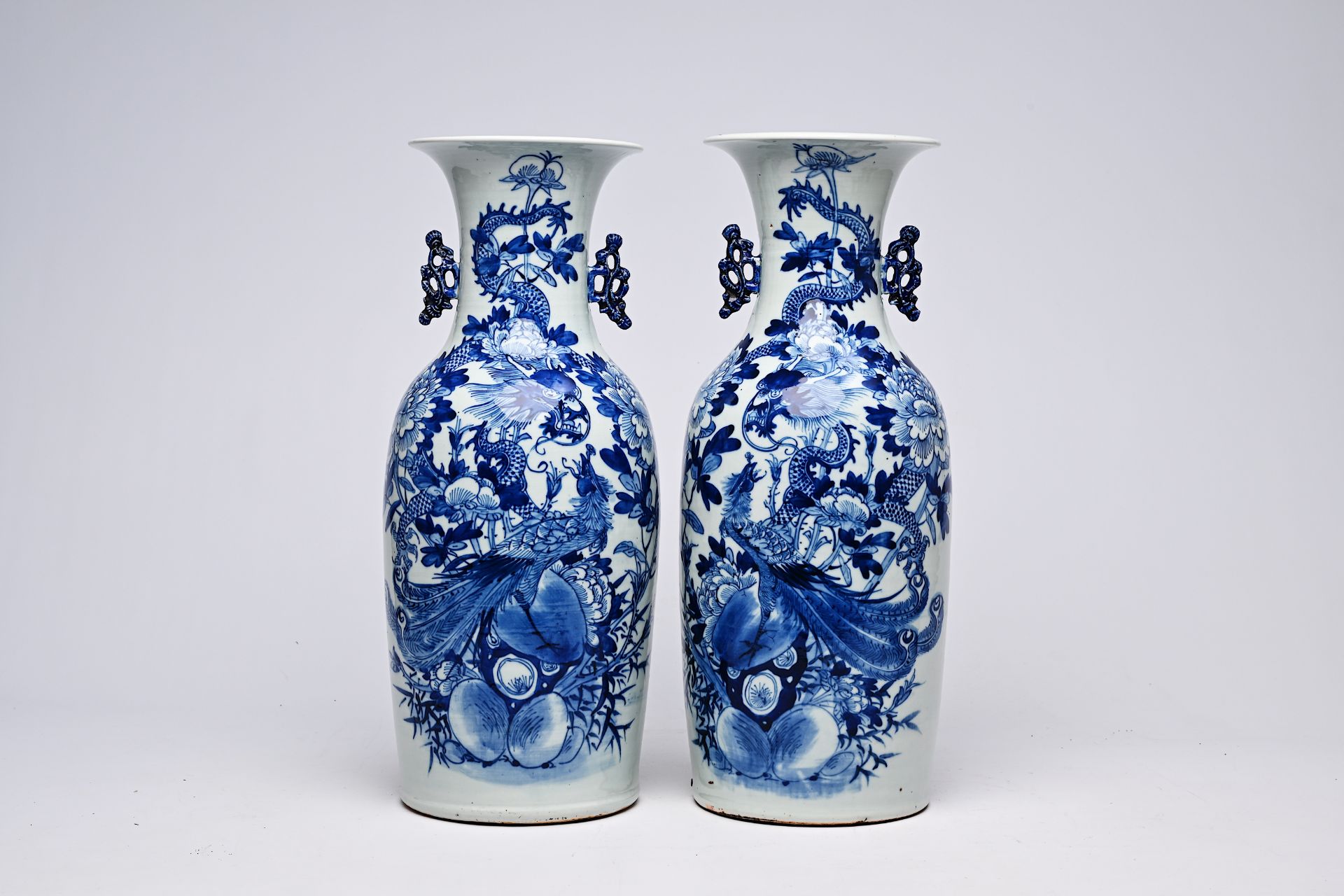 A pair of Chinese blue and white celadon ground vases with a dragon and a phoenix among blossoming b