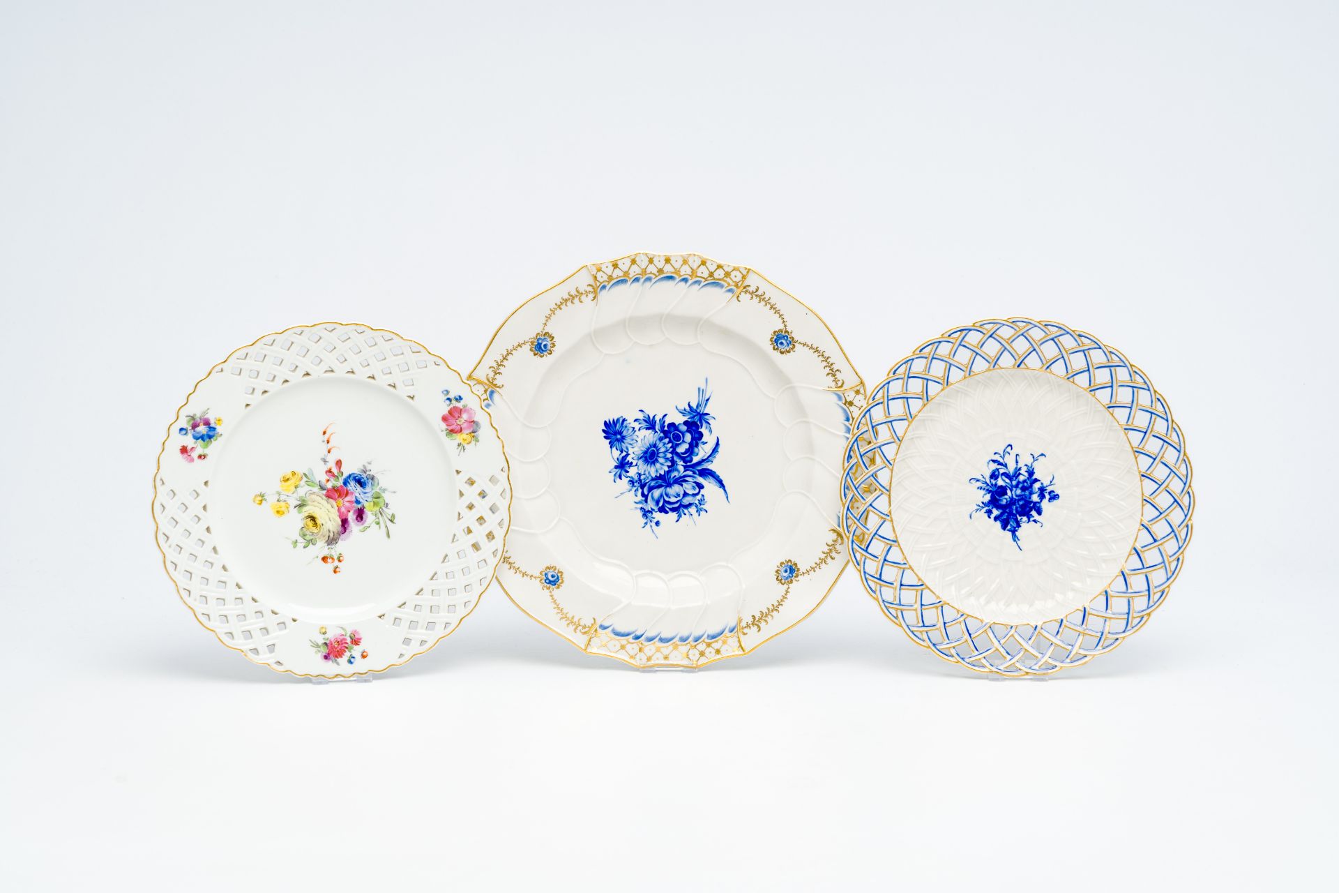 Three polychrome porcelain plates with floral design, Tournai and The Hague, 18th C.