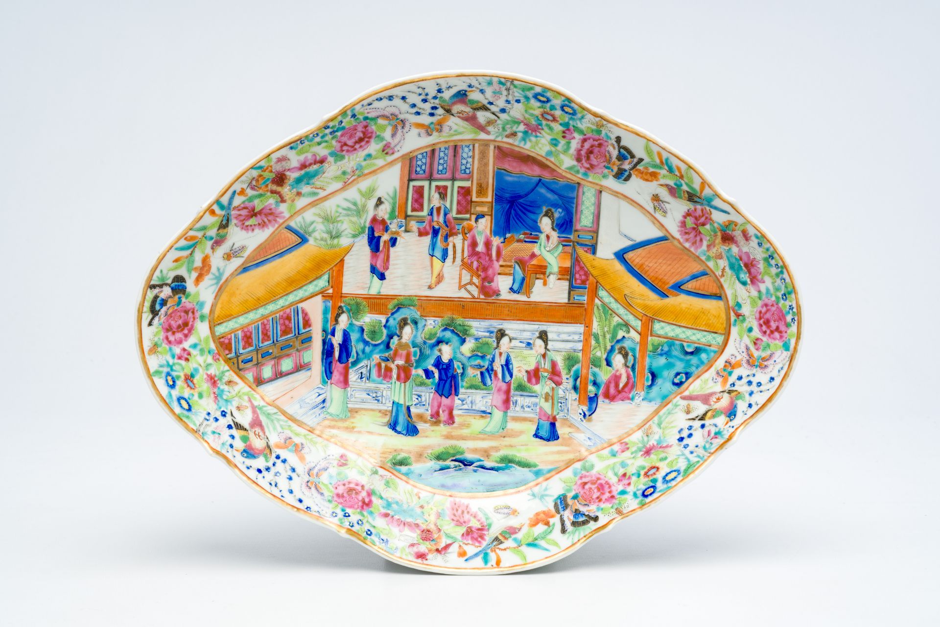 A Chinese Canton famille rose lobed bowl on foot with an animated palace scene and floral design, 19