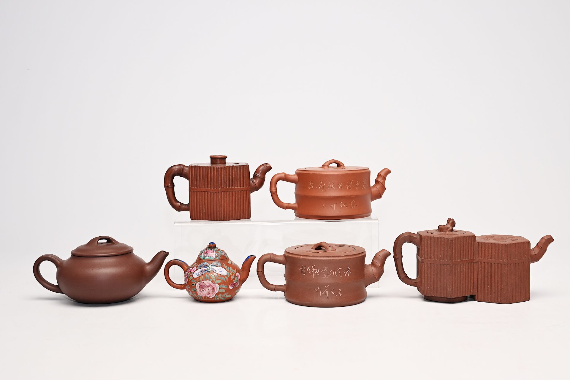 Six various Chinese Yixing stoneware teapots and covers one with enamelled design, 19th/20th C.