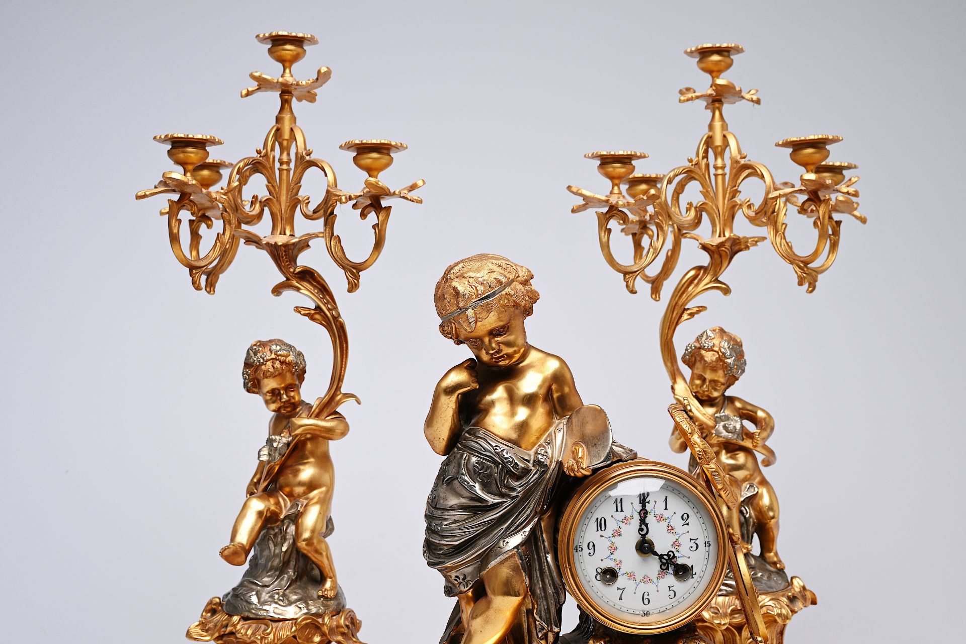 A French three-piece partly gilt metal clock garniture with putti, 20th C. - Image 6 of 11