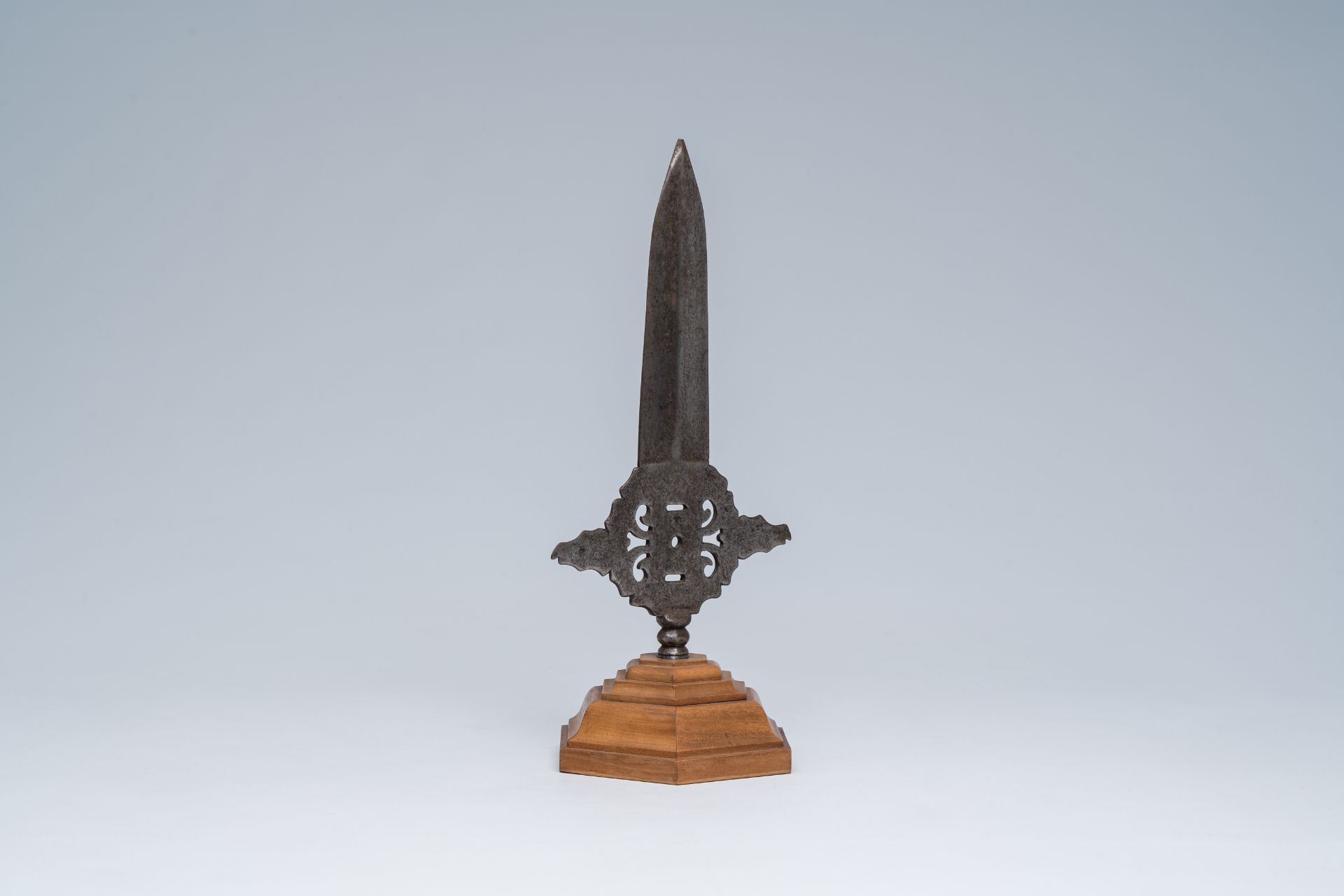 An open worked wrought iron spearhead on a wood stand, 19th C. or earlier