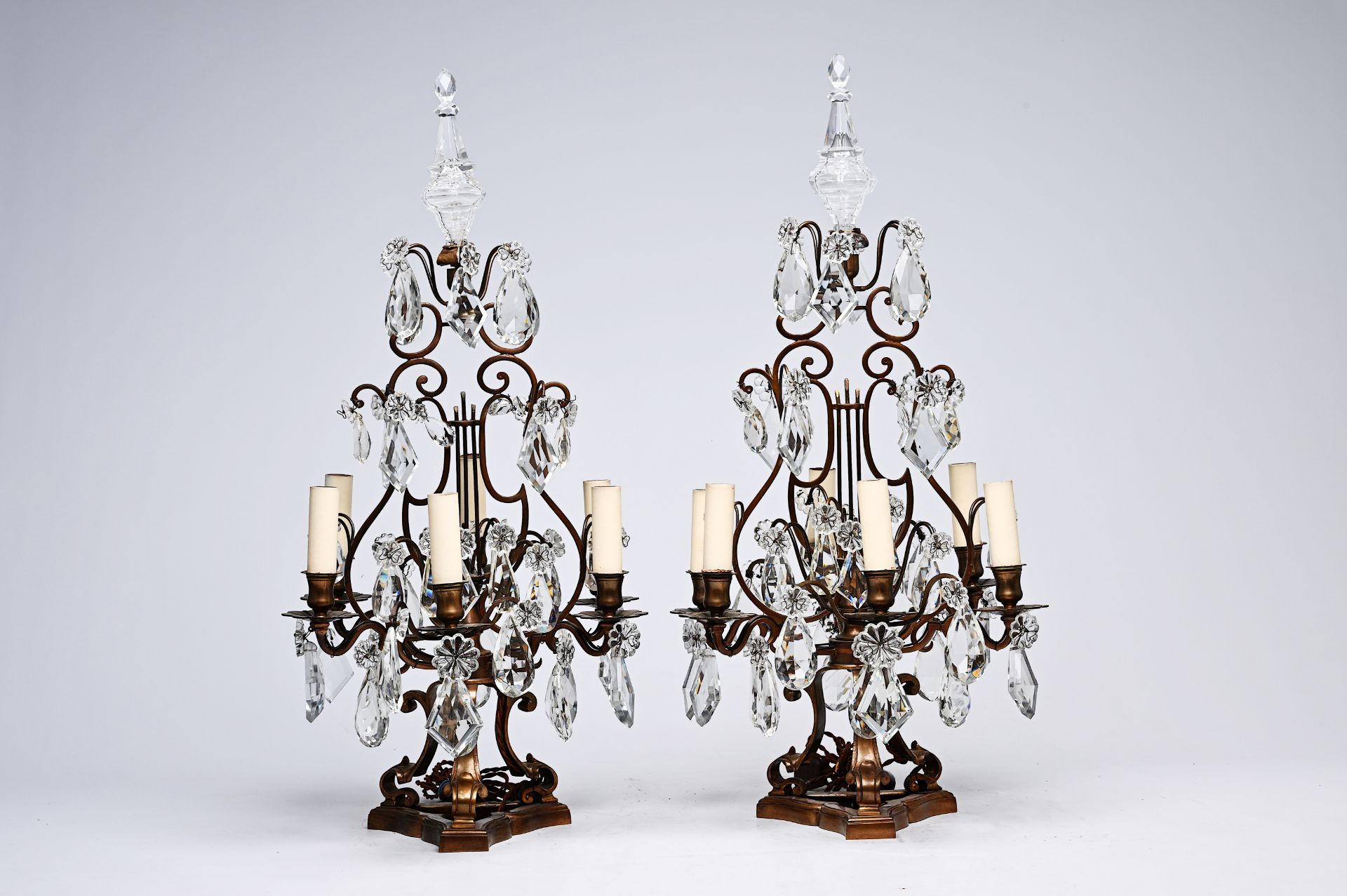 A pair of French Louis XIV style patinated bronze and cut crystal six-lights girandoles, early 20th