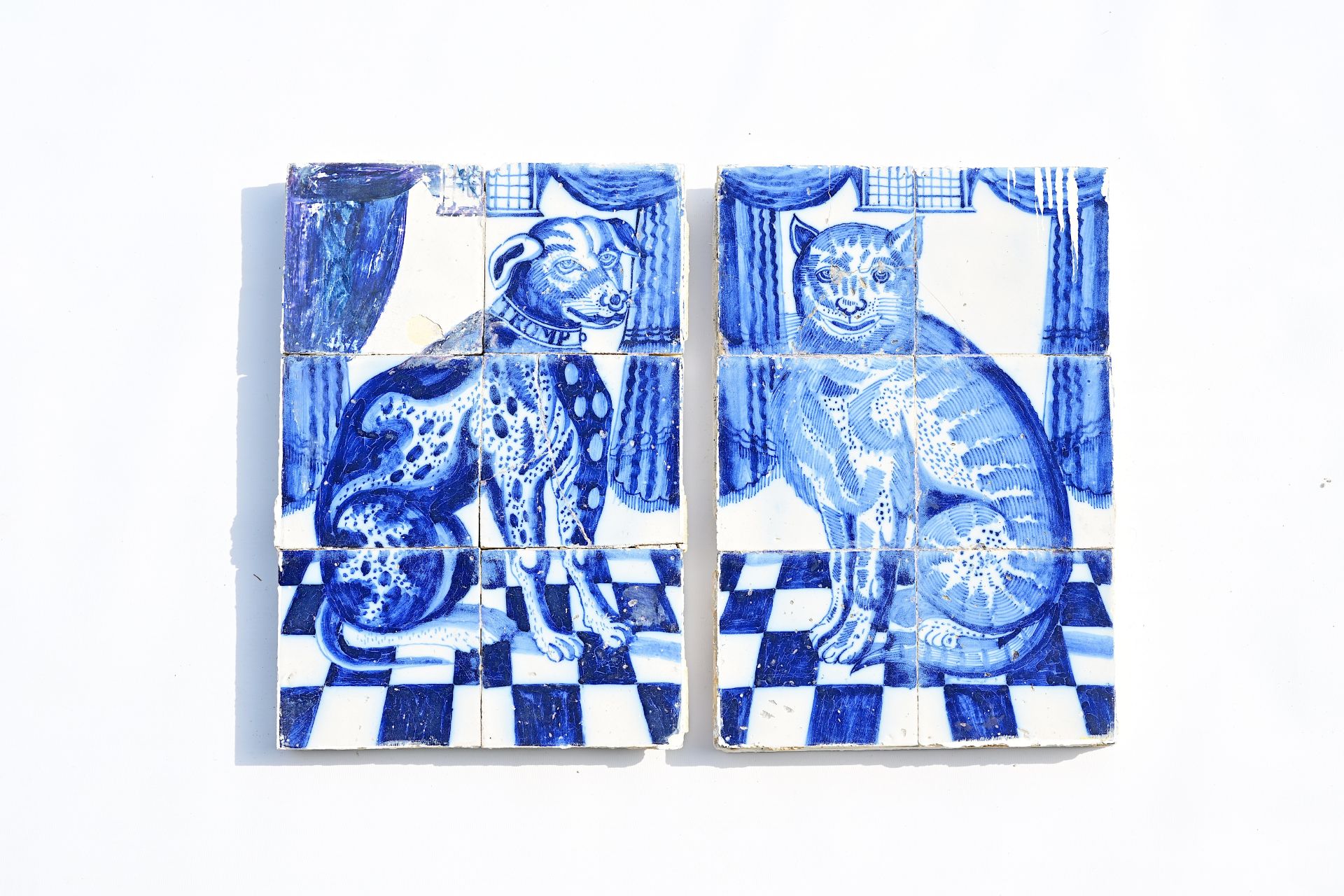 A pair of Dutch Delft blue and white tile murals with a cat and a dog ('Tromp'), 18th C.