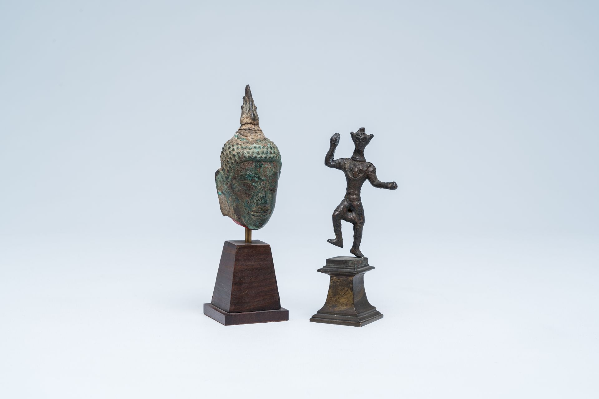 A bronze head of Buddha and a sculpture of a ritual dancer, Southeast Asia, 13th/17th C.