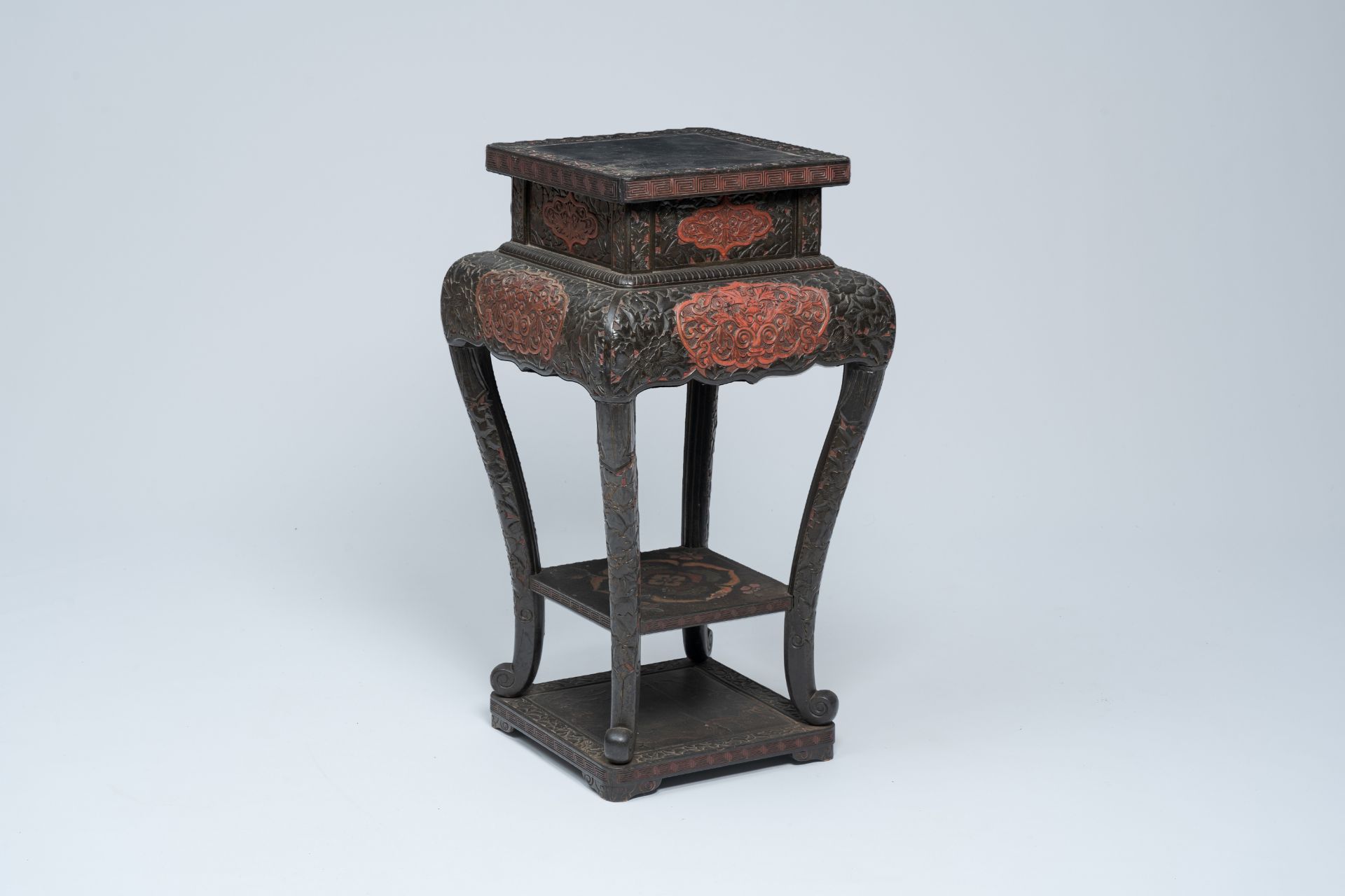 A Japanese red and black lacquered wood stand with floral design, Meiji, 19th/20th C.