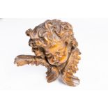 A large carved wood Baroque style head of a mischievous angel, 19th C.