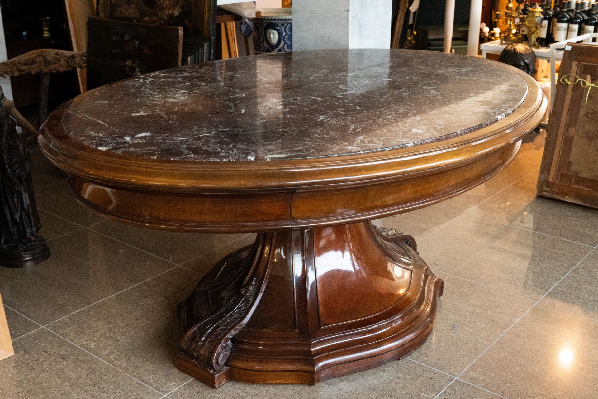 An impressive oval English mahogany table with marble top, 19th C.
