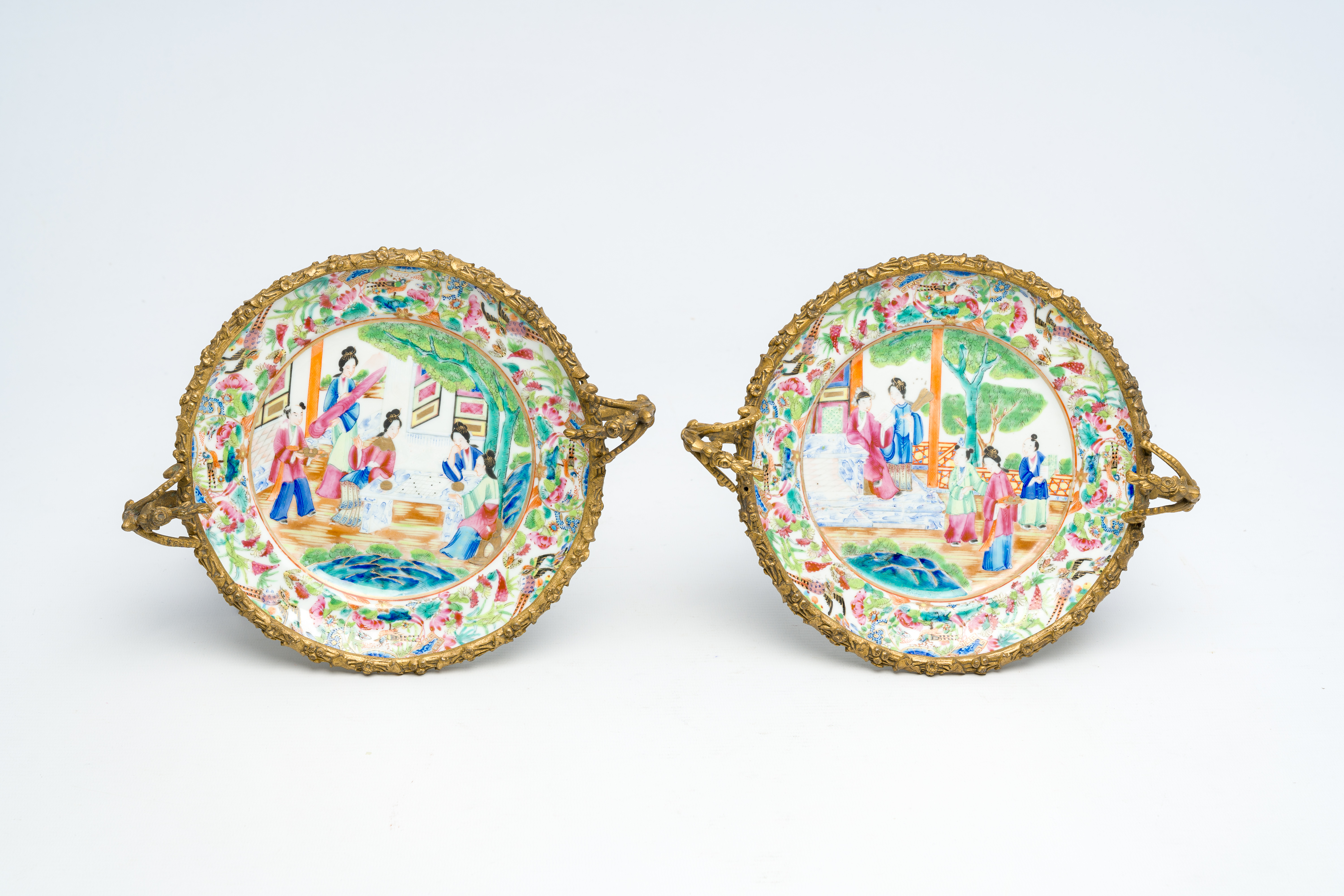 Two Chinese Canton famille rose gilt bronze mounted plates with figures on a terrace, 19th C.