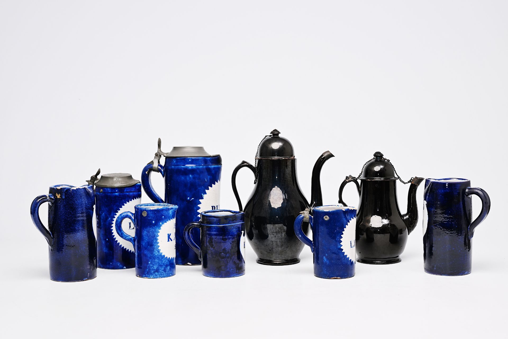Seven blue and white Brussels faience beer mugs and two black-glazed Namur pottery ewers, 18th/19th