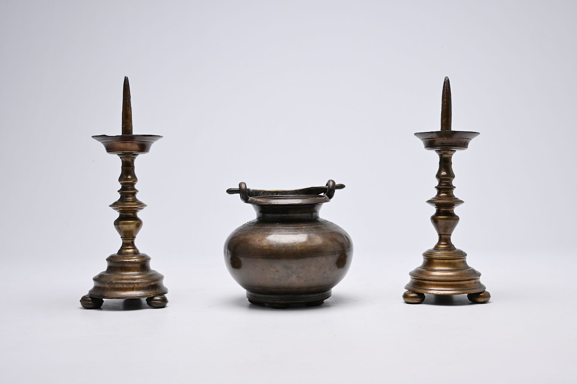 A pair of Italian bronze candlesticks and a holy water bucket, 16th/17th C.