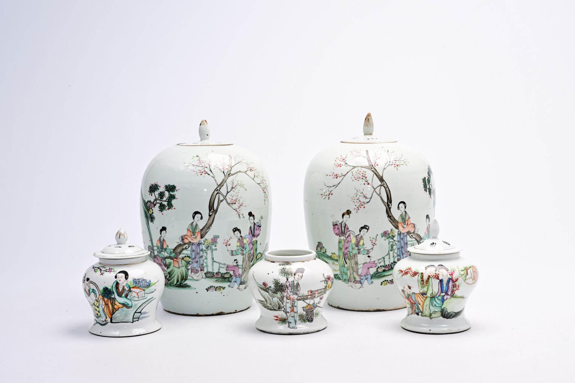 Five various Chinese famille rose and qianjiang cai jars and covers with ladies and children on a te