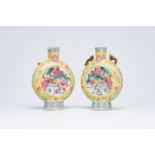 A pair of Chinese famille rose yellow ground moon flasks with warrior scenes and pheasants among blo