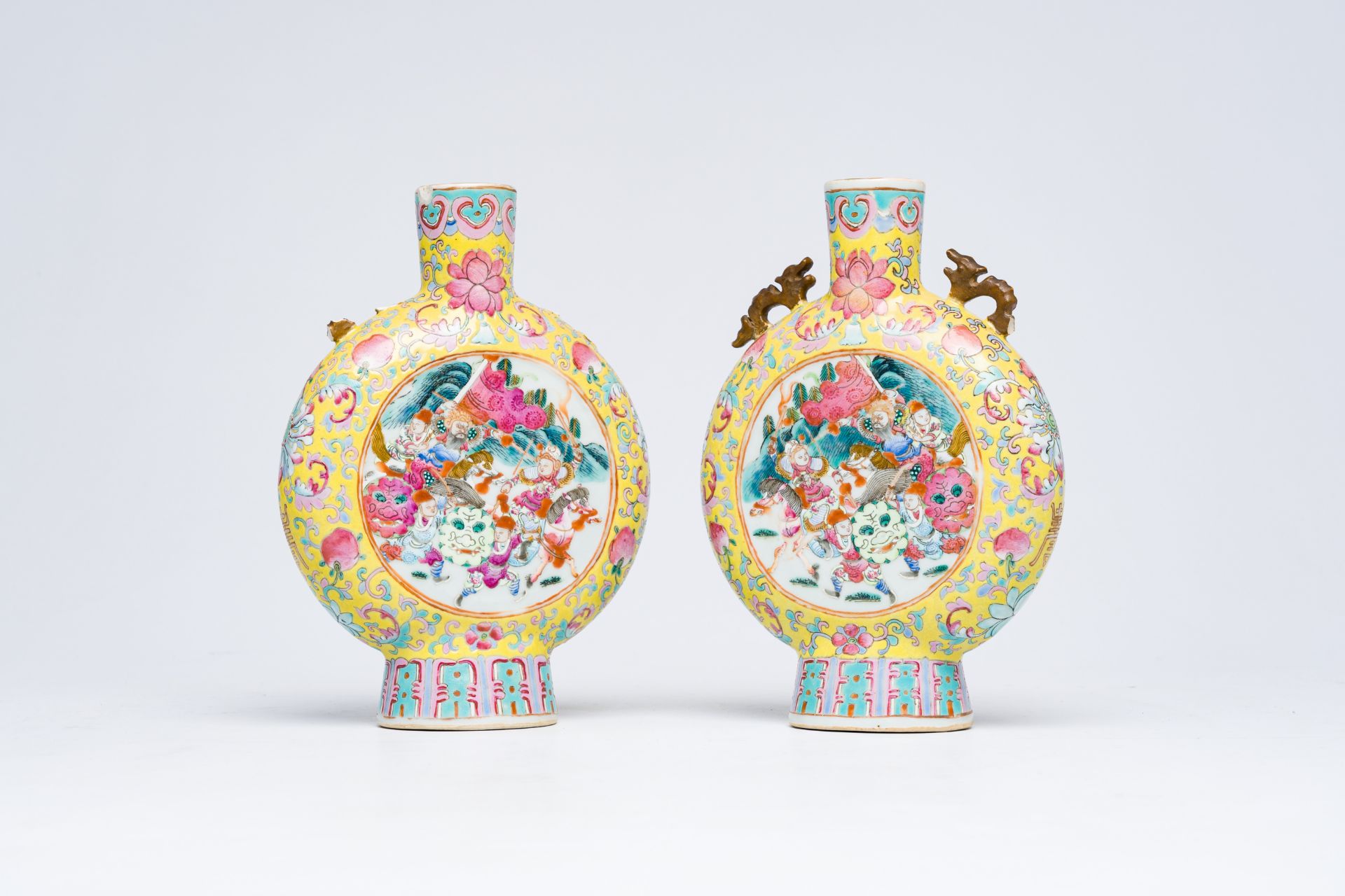 A pair of Chinese famille rose yellow ground moon flasks with warrior scenes and pheasants among blo