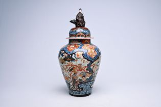 A Japanese Imari vase and cover with birds among blossoming branches and crowned with a lady, Edo, 1
