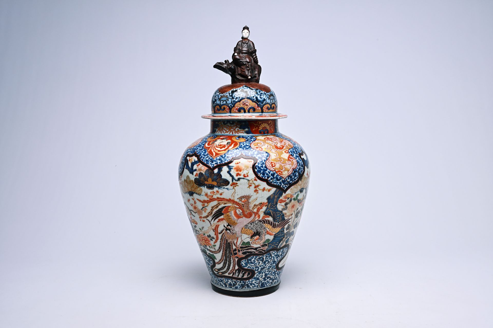 A Japanese Imari vase and cover with birds among blossoming branches and crowned with a lady, Edo, 1