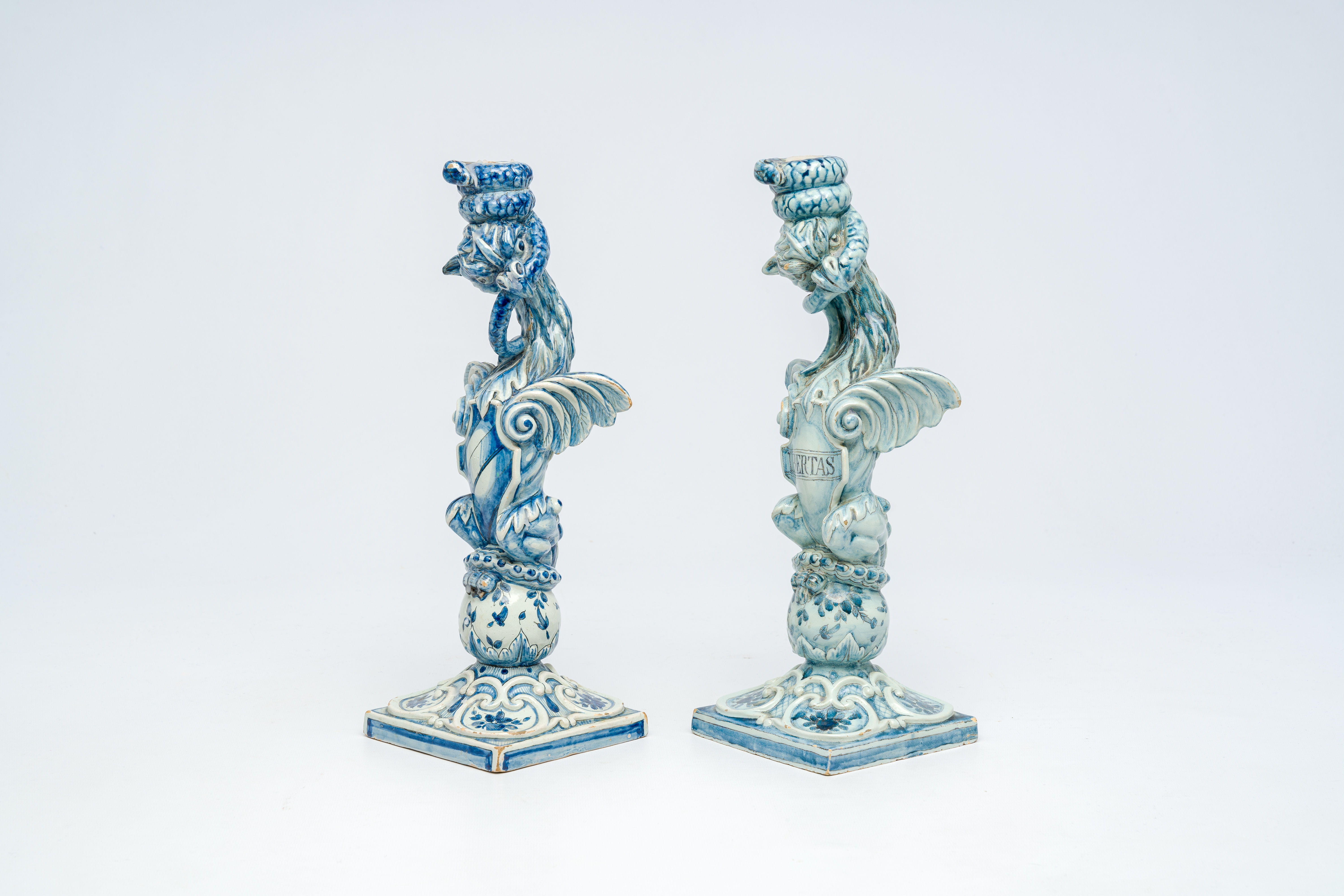 A pair of blue and white Italian pottery 'griffin' candlesticks, Cantagalli, late 19th C.