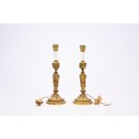 A pair of French Neoclassical gilt bronze candlesticks with lion heads and garlands mounted as lamps