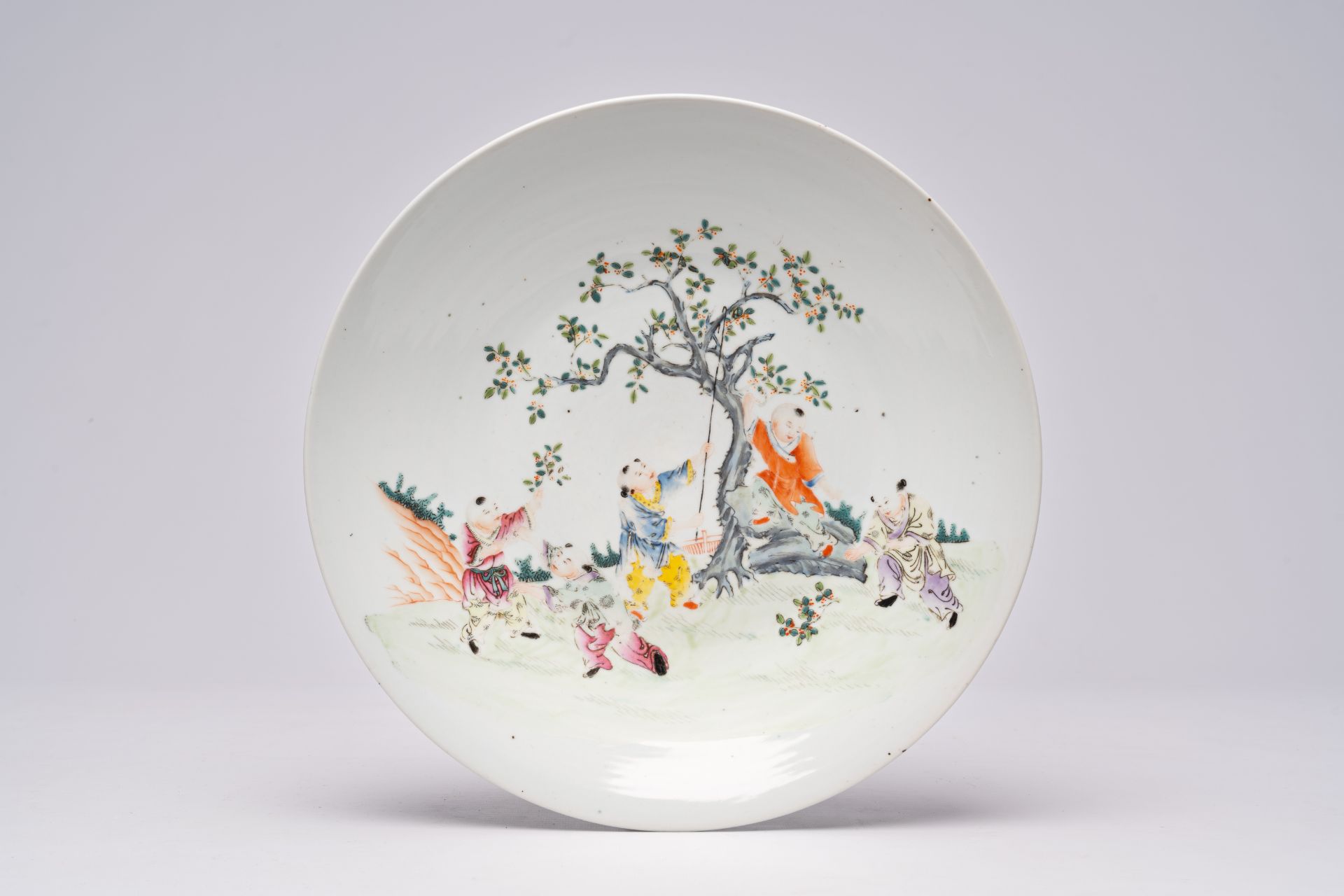 A Chinese famille rose dish with playing boys in a garden, Qianlong mark, first half 20th C. - Image 2 of 4