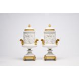 A pair of French biscuit gilt bronze mounted vases and covers with a frieze with bacchantes, Sevres