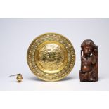 A German brass 'Adam and Eve' alms dish, a holy water font and a carved wood putto, 17th/18th C.