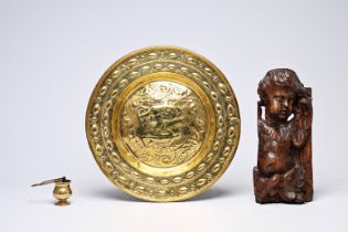 A German brass 'Adam and Eve' alms dish, a holy water font and a carved wood putto, 17th/18th C.