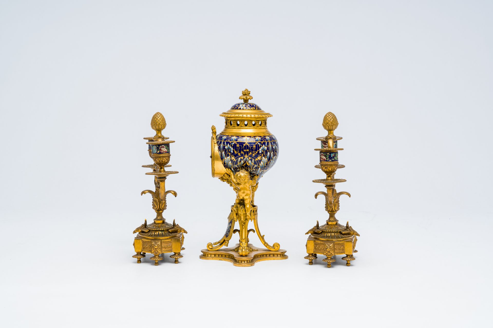 A French gilt bronze and cloisonne three-piece clock garniture with putti, 19th C. - Image 4 of 7