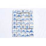 A varied collection of Dutch Delft blue and white tiles with flowers, boats, animals, sea monsters a