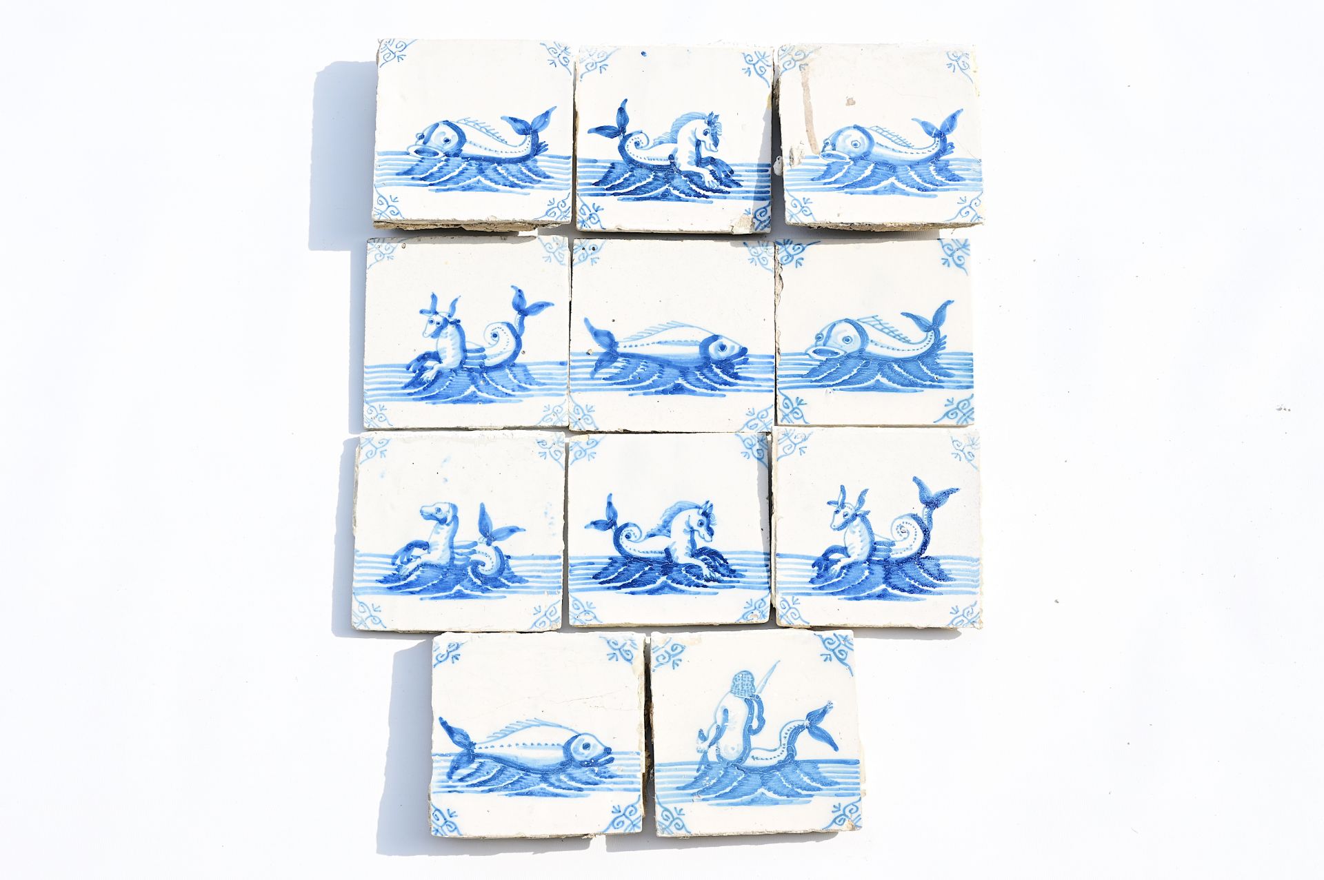 Eleven Dutch Delft blue and white 'sea monster' tiles, 19th C.