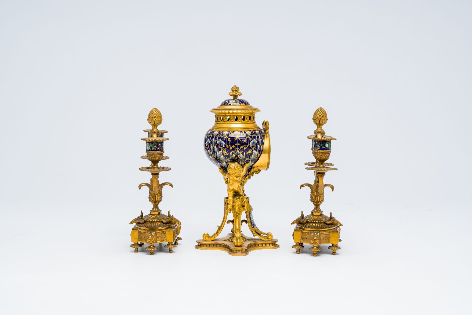 A French gilt bronze and cloisonne three-piece clock garniture with putti, 19th C. - Image 3 of 7