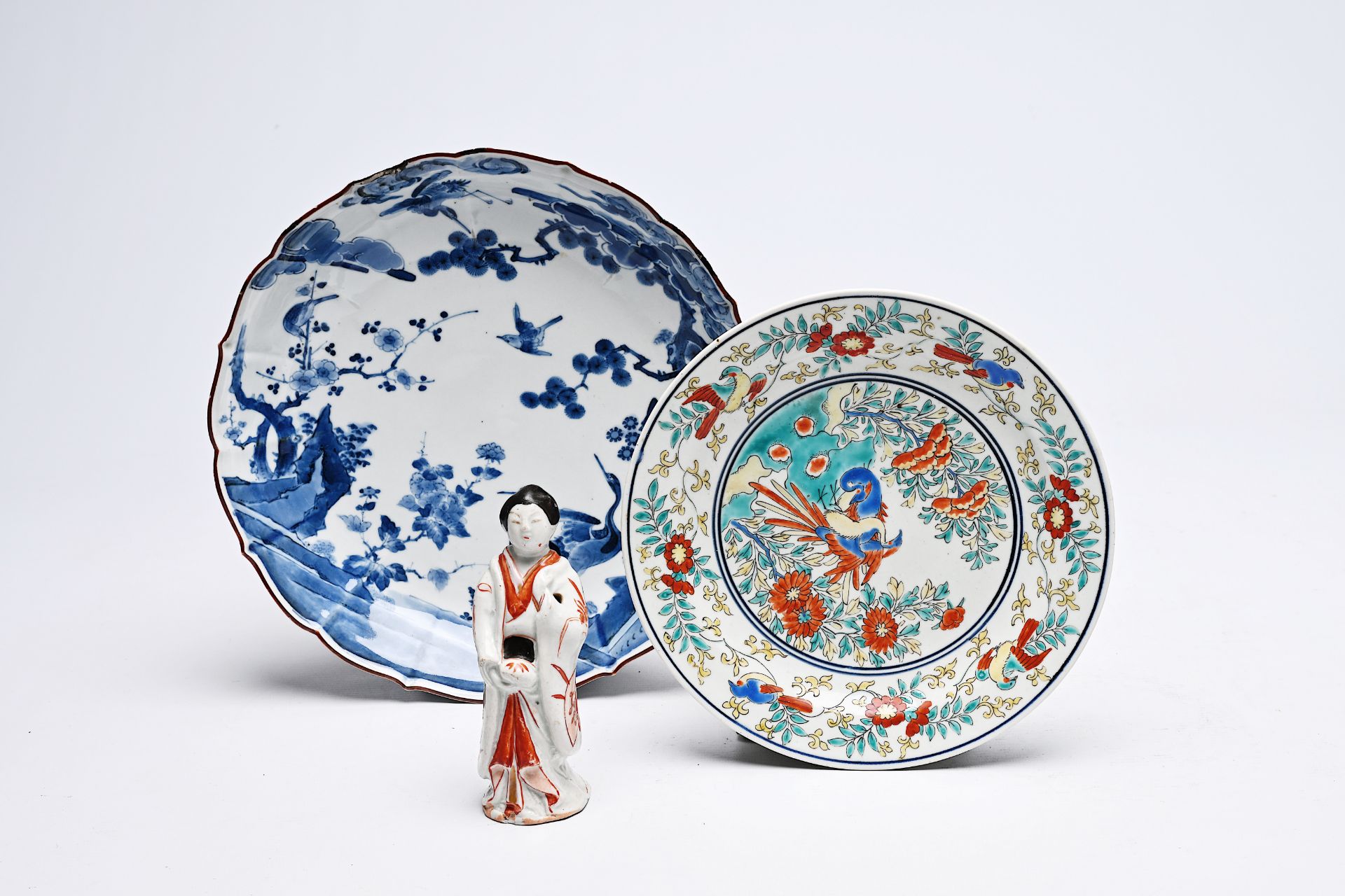 A Japanese blue and white and a Kakiemon plate with birds in a landscape and a 'bijin' figure, Edo/M