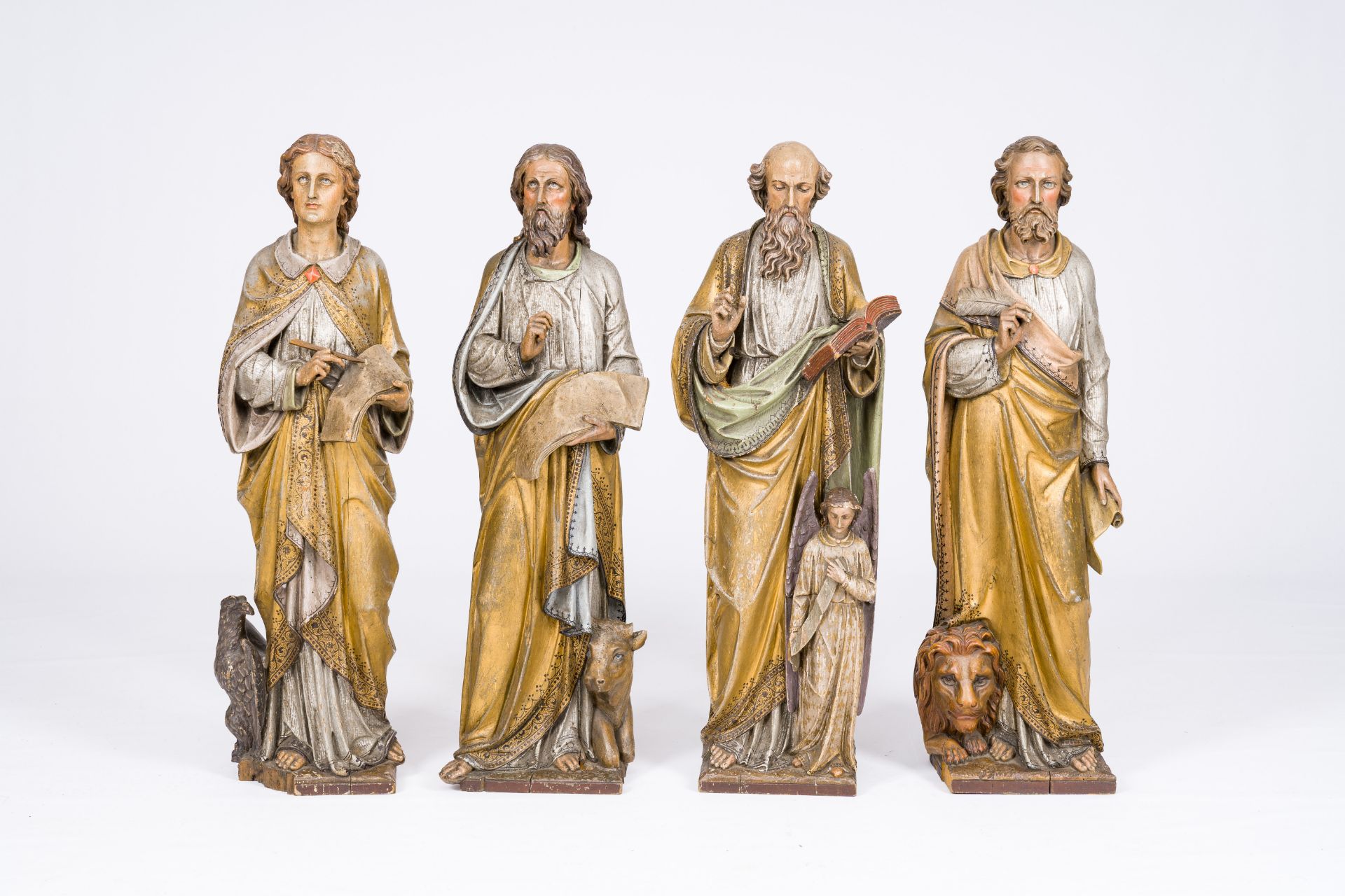 Four large Gothic revival carved, polychromed and gilt limewood 'evangelist' figures, probably Germa